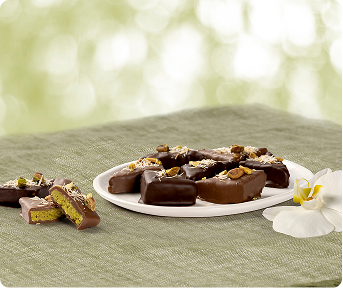 Plate of dubai chocolate du'lights topped with pistachios.